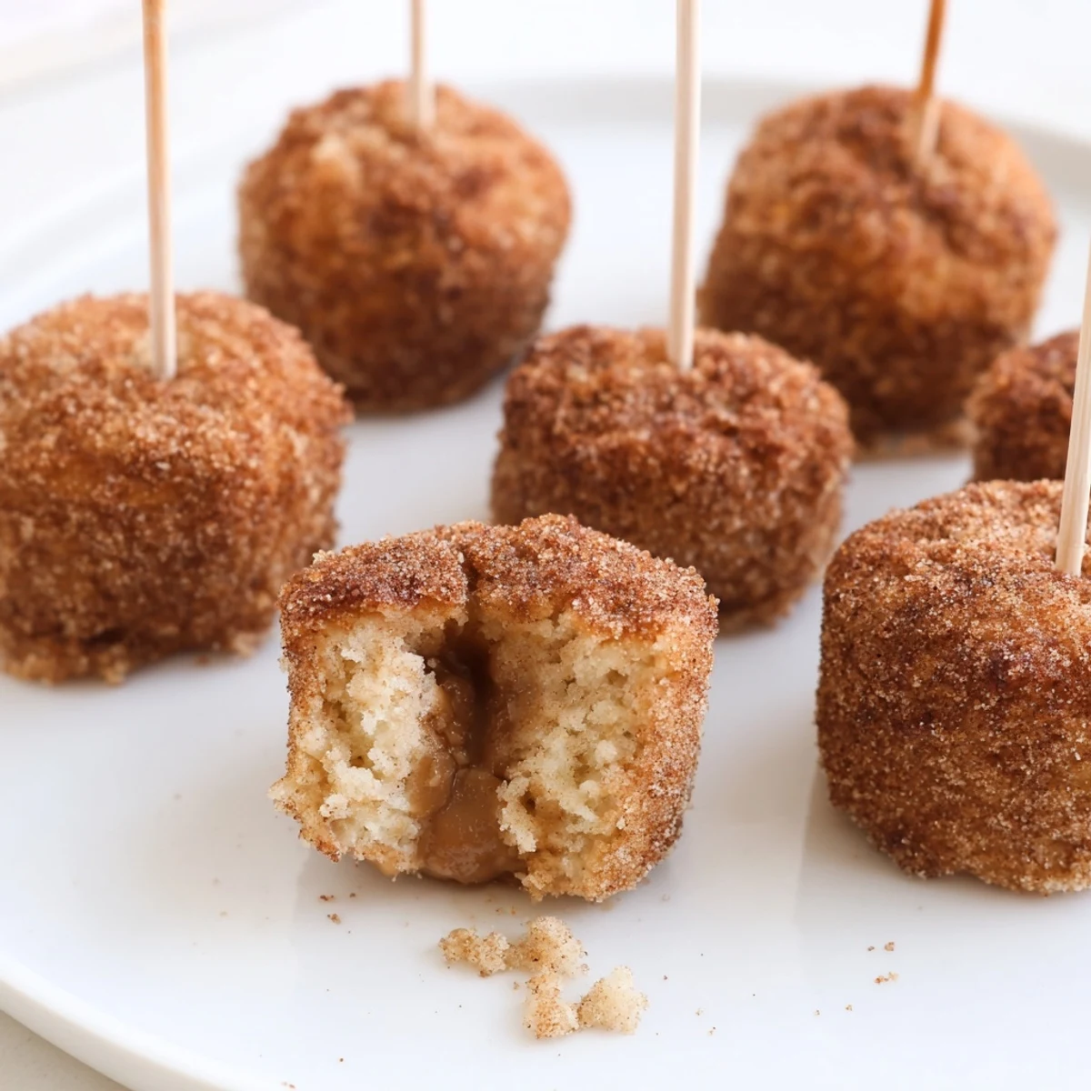 Deliciously spiced muffin pops with caramel centers, coated in cinnamon sugar delight.  