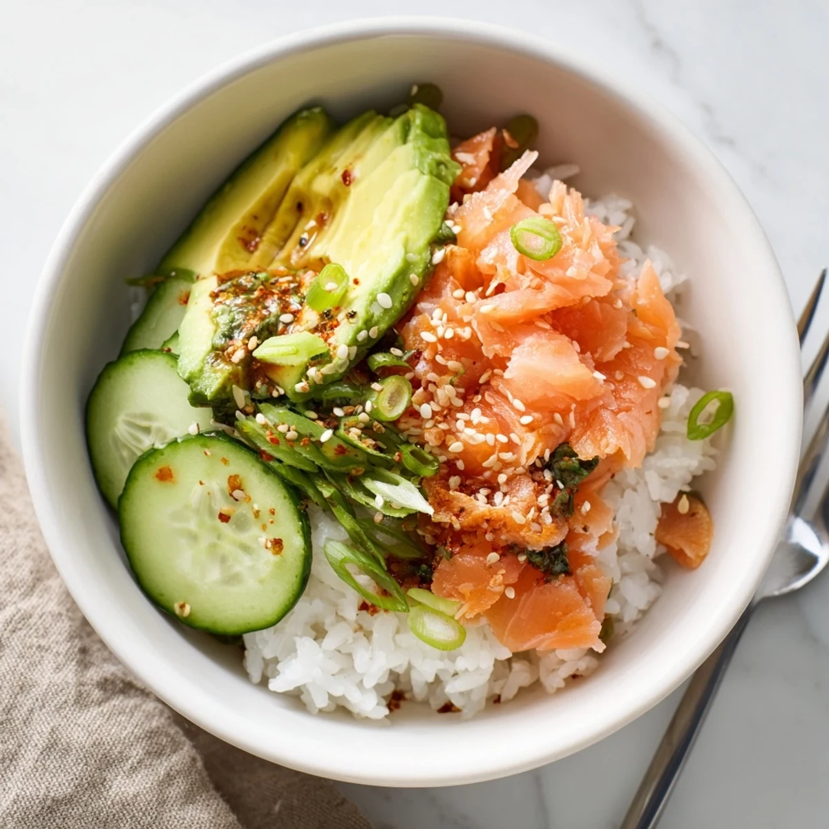 Delicious leftover salmon and rice bowl topped with fresh avocado and sesame seeds.  