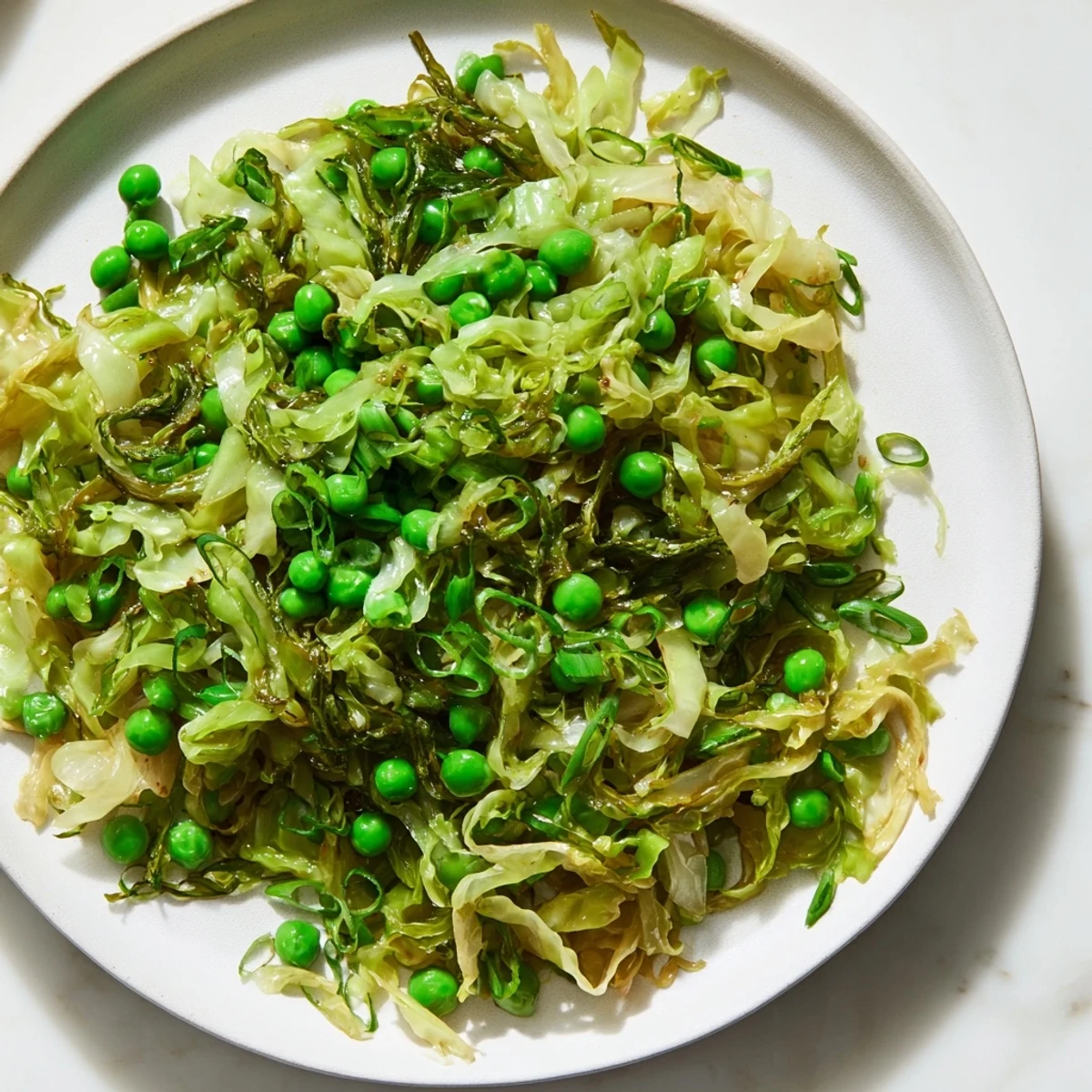 Hot, fresh cabbage stir-fry with soy sauce, peas, garlic, ready to serve as a side dish.