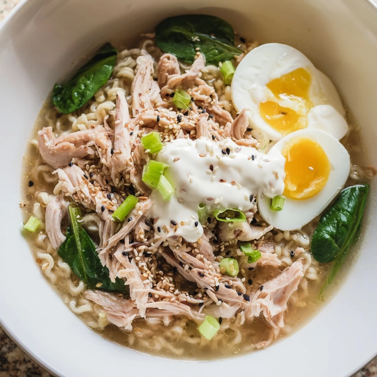 Steaming bowls of chicken ramen, drizzled with Kewpie mayo, garnished with nori and sesame seeds.