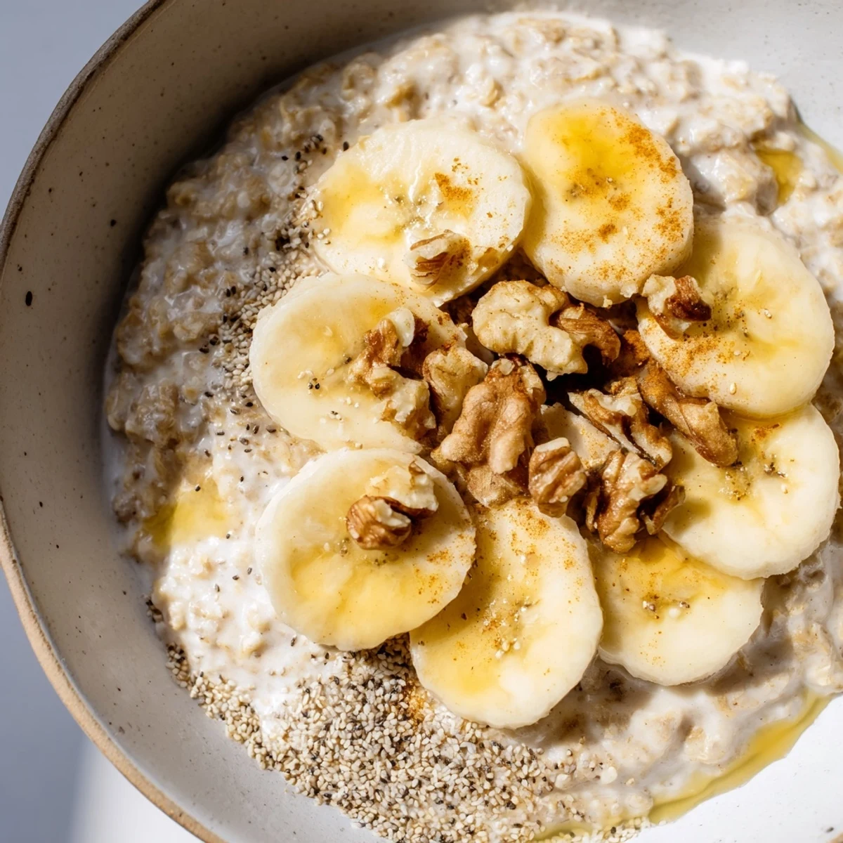 A close-up image shows a creamy, perfectly cooked Microwave Banana Oats breakfast ready to eat.