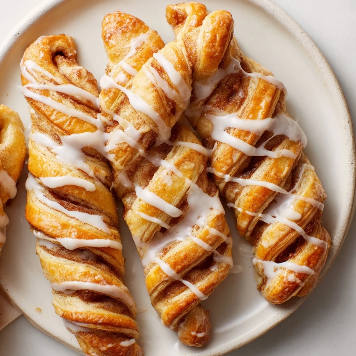 Freshly air-fried cinnamon roll twists, swirled with cinnamon sugar, ready to be devoured with your morning coffee.