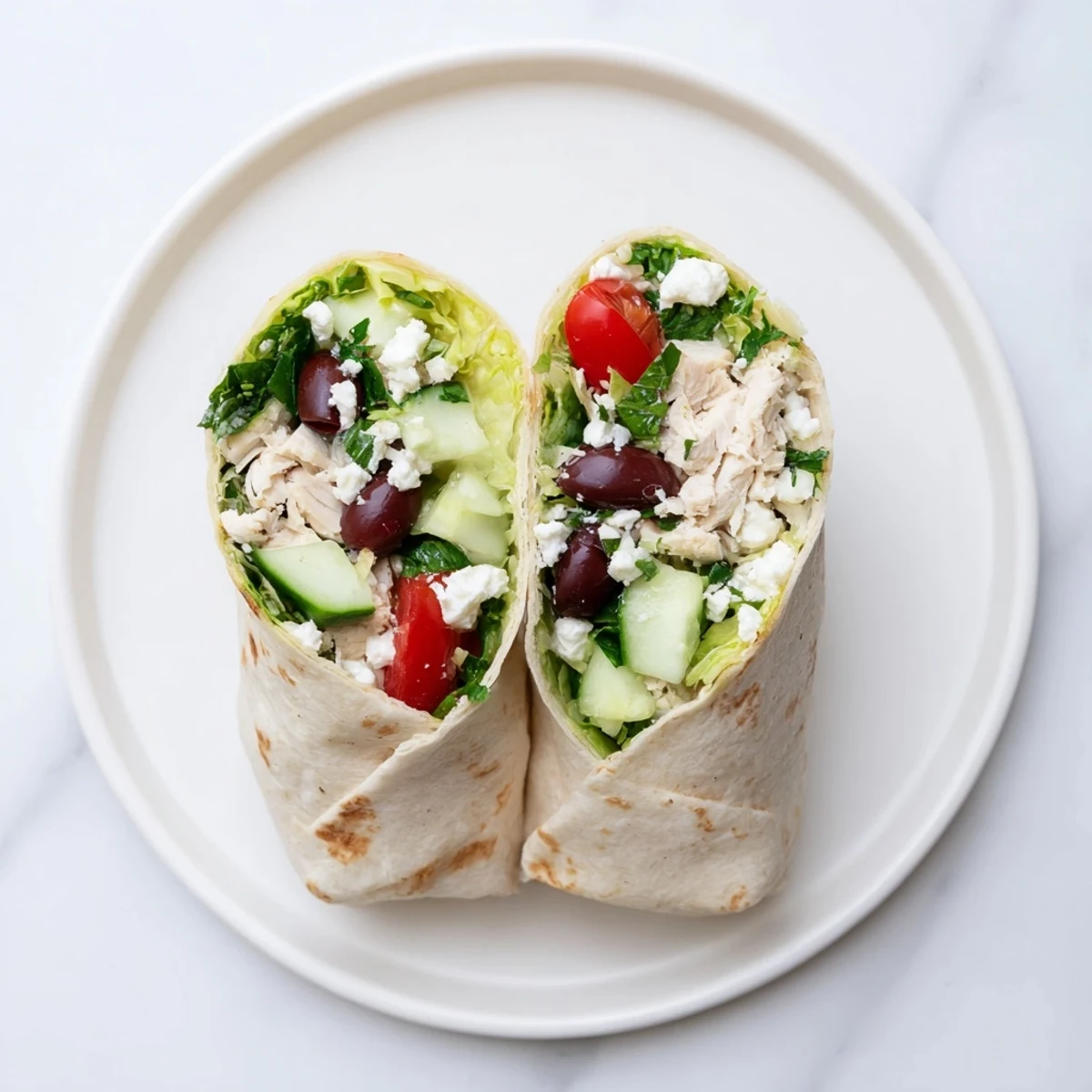 Warm Greek Lemon Chicken Salad Wrap filled with juicy grilled chicken, crisp cucumbers, tomatoes, and tangy feta cheese.