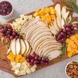 This delicious Turkey Cheese and Cracker Board features sliced turkey, assorted crackers, and festive garnishes like grapes.