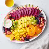 A stunning Dragon Scales Fruit and Dip Board features a delicious array of fresh, sliced fruits ready to eat.