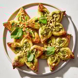 Warm, flaky Savory Bites: Star-Shaped Pesto Pinwheels showcase vibrant green pesto and a delicious Parmesan flavor.