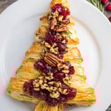 Festive holiday appetizer, a warm Brie en Croûte Pine Tree, ready to be served with crackers and wine.