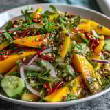 A close-up of the Refreshing Mango Salad with Lime Dressing featuring juicy mango, red bell pepper, and chilies.
