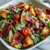 Deconstructed Italian Sub Crunch Bowls, a vibrant mix topped with zesty dressing.