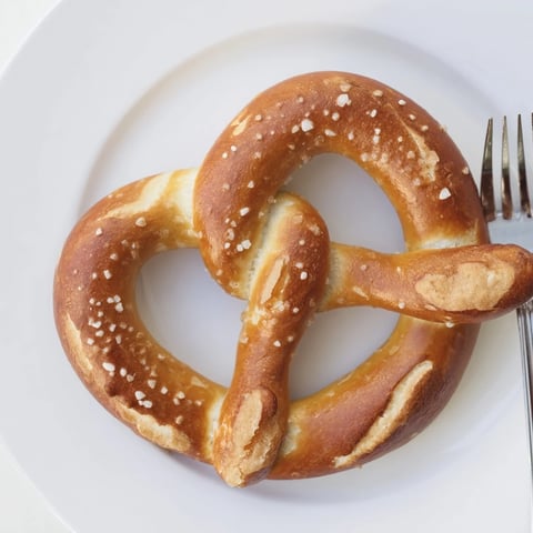 Golden brown Bretzels Anneau de Fête, generously salted, ready to serve with mustard for dipping.