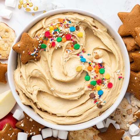 A creamy Gingerbread House Dip board, festive and ready, surrounded by dippable treats.
