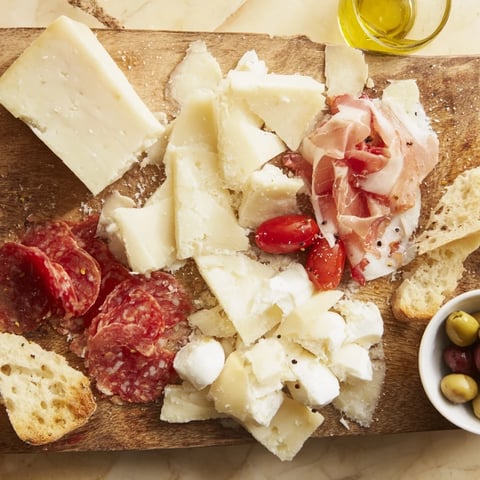 Rustic Italian Farmhouse Board displays a beautiful arrangement of cheeses, meats, and fresh bread.