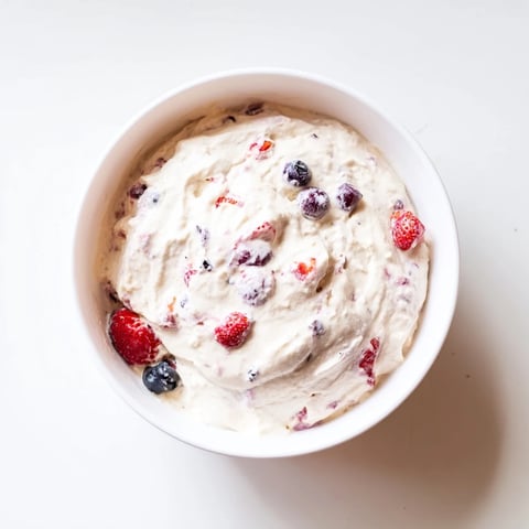 Smooth and creamy cottage cheese ice cream swirled with vibrant berries, a delightful frozen treat.