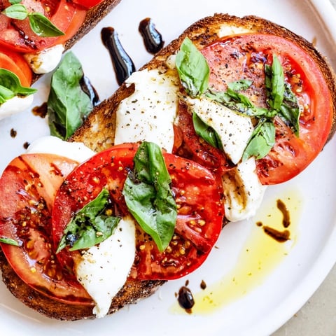Golden sourdough supporting colorful tomato burrata toast, a fresh Italian brunch appetizer.