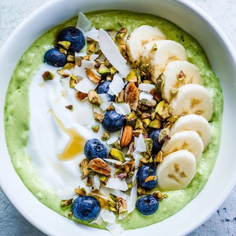 Vibrant green Matcha Overnight Oats topped with fresh berries, ready for a delicious breakfast.