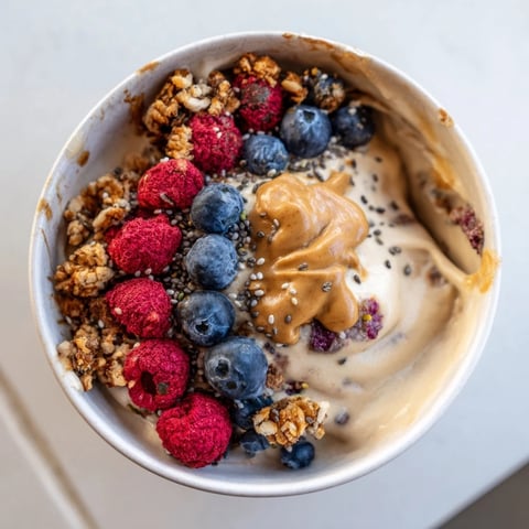 Smooth protein ice cream bowls topped with berries and granola, a healthy dessert option.