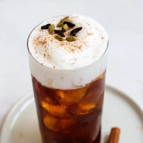 Homemade Iced Chai with cold foam, a beautifully layered drink with creamy foam, offering cool refreshment.