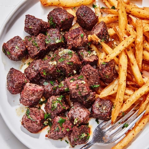 Savory blackened Cajun steak bites tossed with golden fries for a delicious meal.  