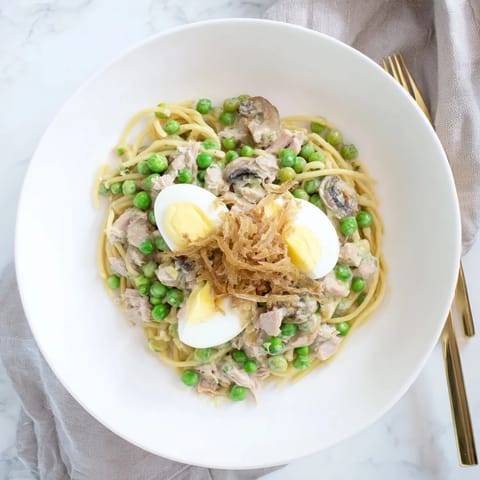 A comforting baked dish of Tuna Noodle Casserole, with visible tender noodles and a bubbling, cheesy sauce.