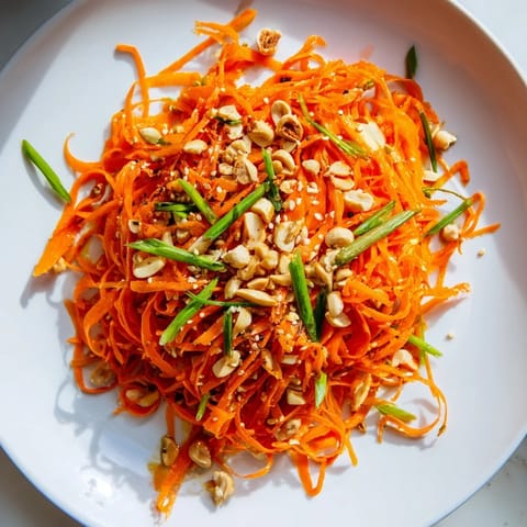 Close-up of a refreshing Spicy Carrot Salad, showcasing the bright orange carrots and Asian-inspired flavors.