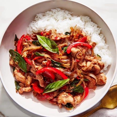 Sizzling wok photo of Thai Basil Chicken Bowls, a flavorful, easy weeknight dinner idea.