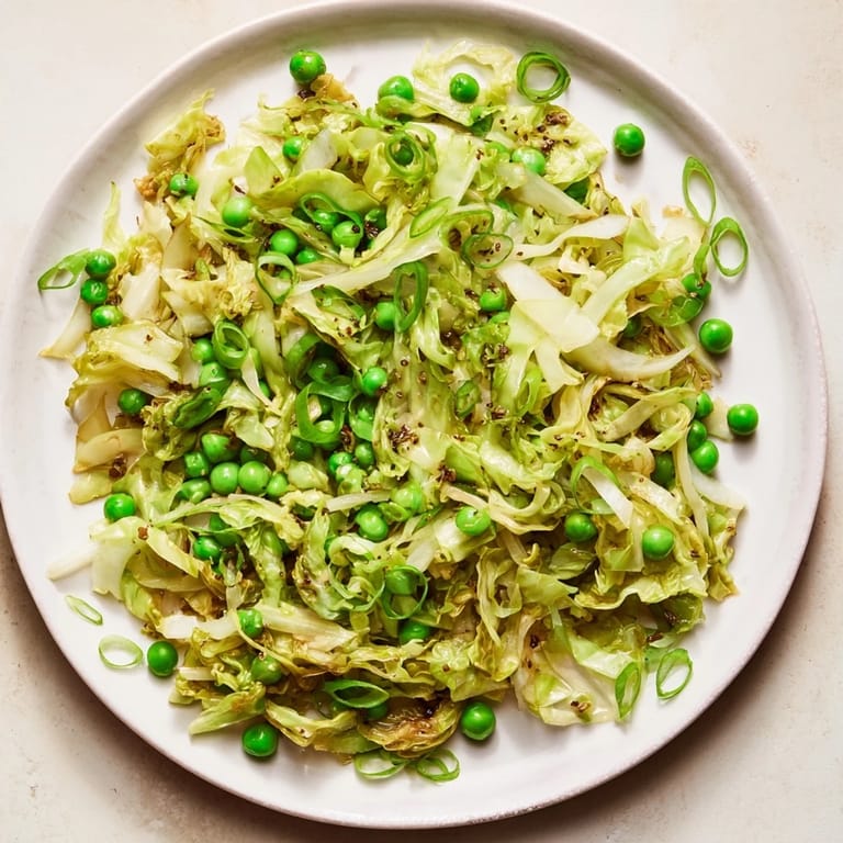 Colorful cabbage stir-fry sizzling in a wok, perfectly seasoned with garlic, soy, and peas.