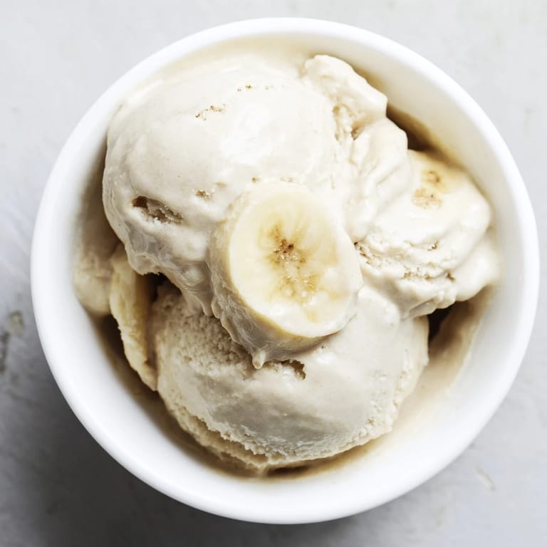 Frozen banana coins being blended into smooth, dreamy 2-Ingredient Banana Ice Cream for a refreshing treat.