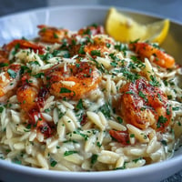 Creamy lemon orzo with shrimp, a vibrant dish glistening with tender seafood.